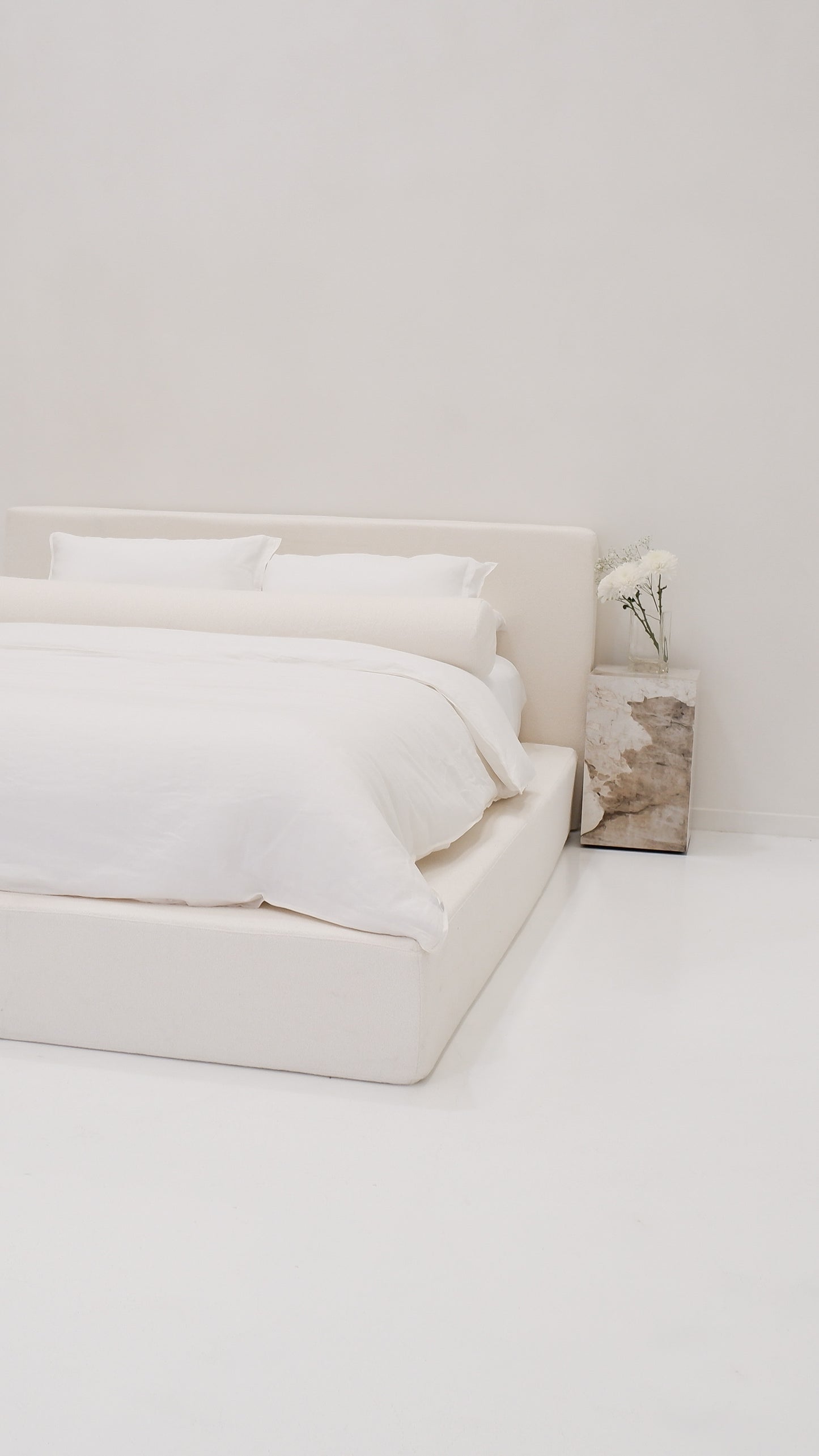 The ultimate Cloud Bed. Create cloud-like comfort in your bedroom with the dreamy CloudFrame bed. Upholstered in a soft, cream bouclè fabric, the bed features a contemporary square shape that redefines the concept of luxury in your bedroom. 